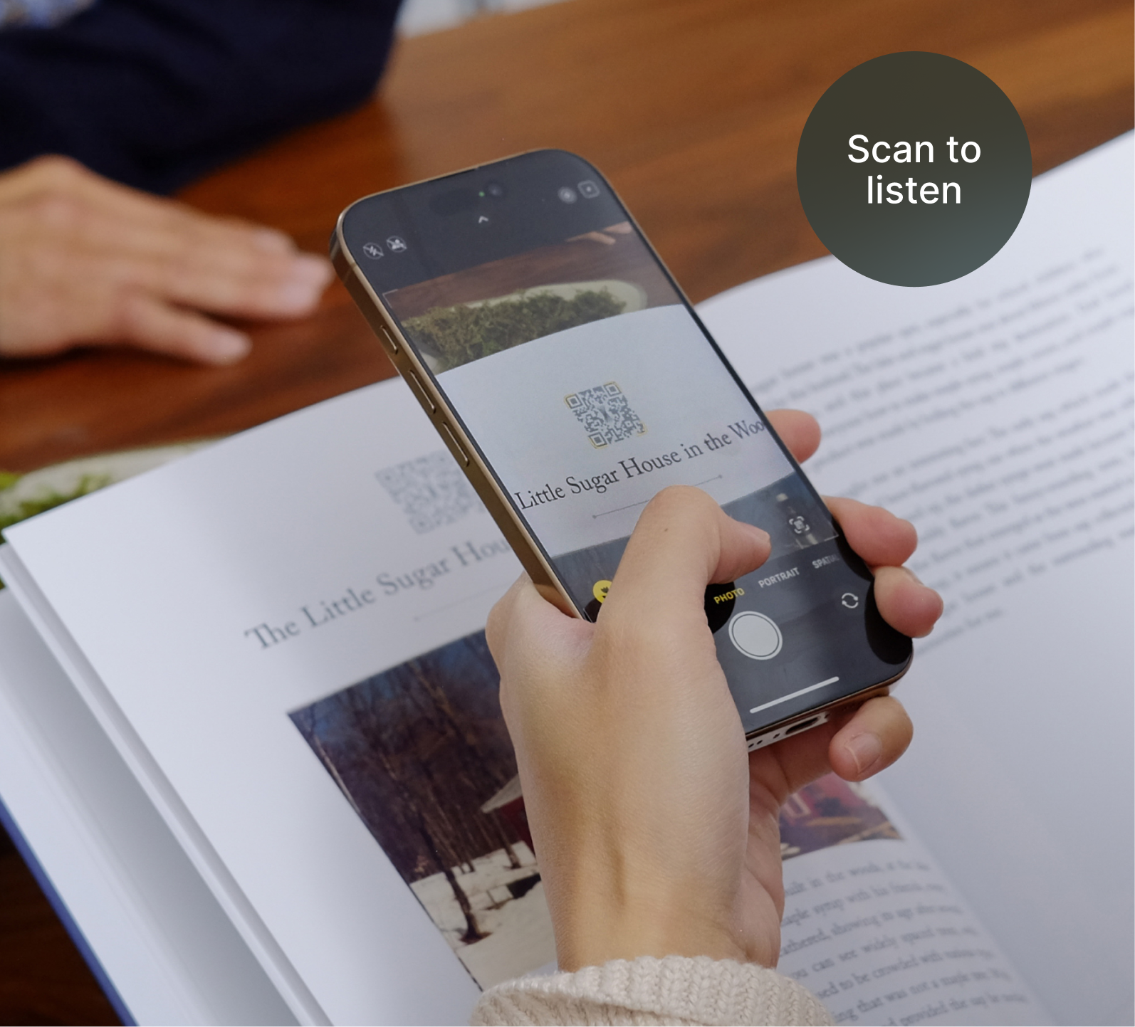 A photo of someone scanning the QR code from an opened Remento book