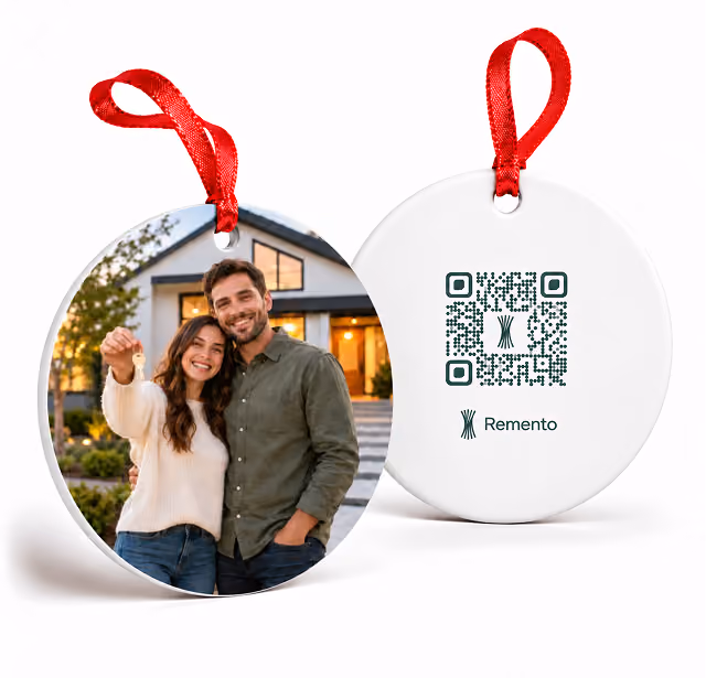 Couple in front of their new house on a new home photo ornament with QR code back