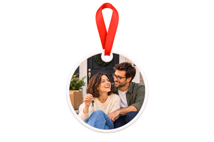 Ceramic new home photo ornament with red ribbon showing a couple on their front steps