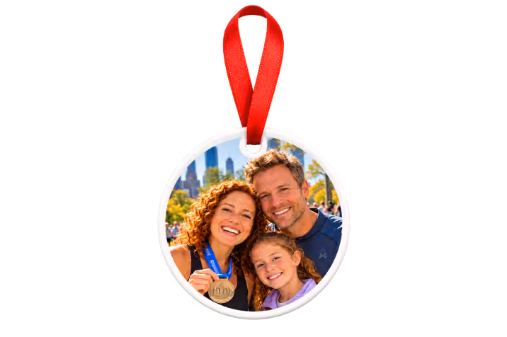 Ceramic highlight of the year photo ornament with red ribbon showing a family celebrating a race medal